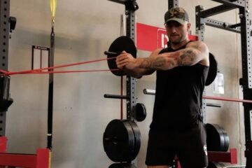 An athlete preparing for a workout with durable stretch bands in a sunny gym.