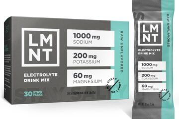 Electrolyte drink packet beside a glass of pink water on a kitchen counter