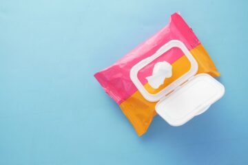 Flushable wet wipes package sitting on a clean marble bathroom countertop.
