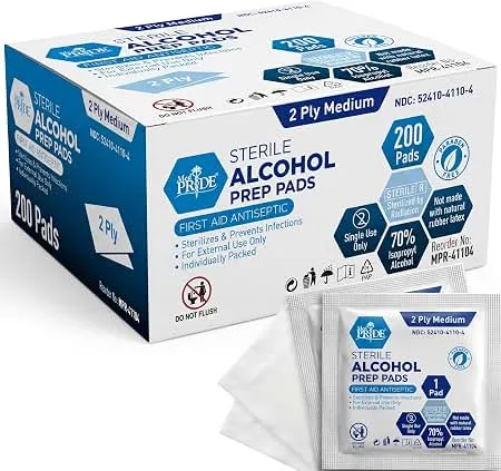 Hands opening an alcohol prep pad packet on a bathroom counter